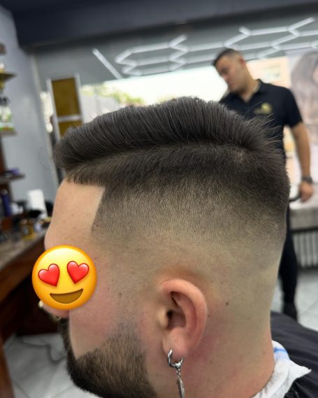 Frisur mit kurzem Fade und gestyltem Oberhaar in einem Friseursalon.