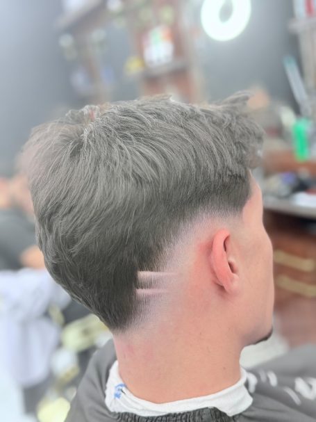 Junger Mann mit kurzen, grauen Haaren und einem modernen Fade-Haarschnitt.